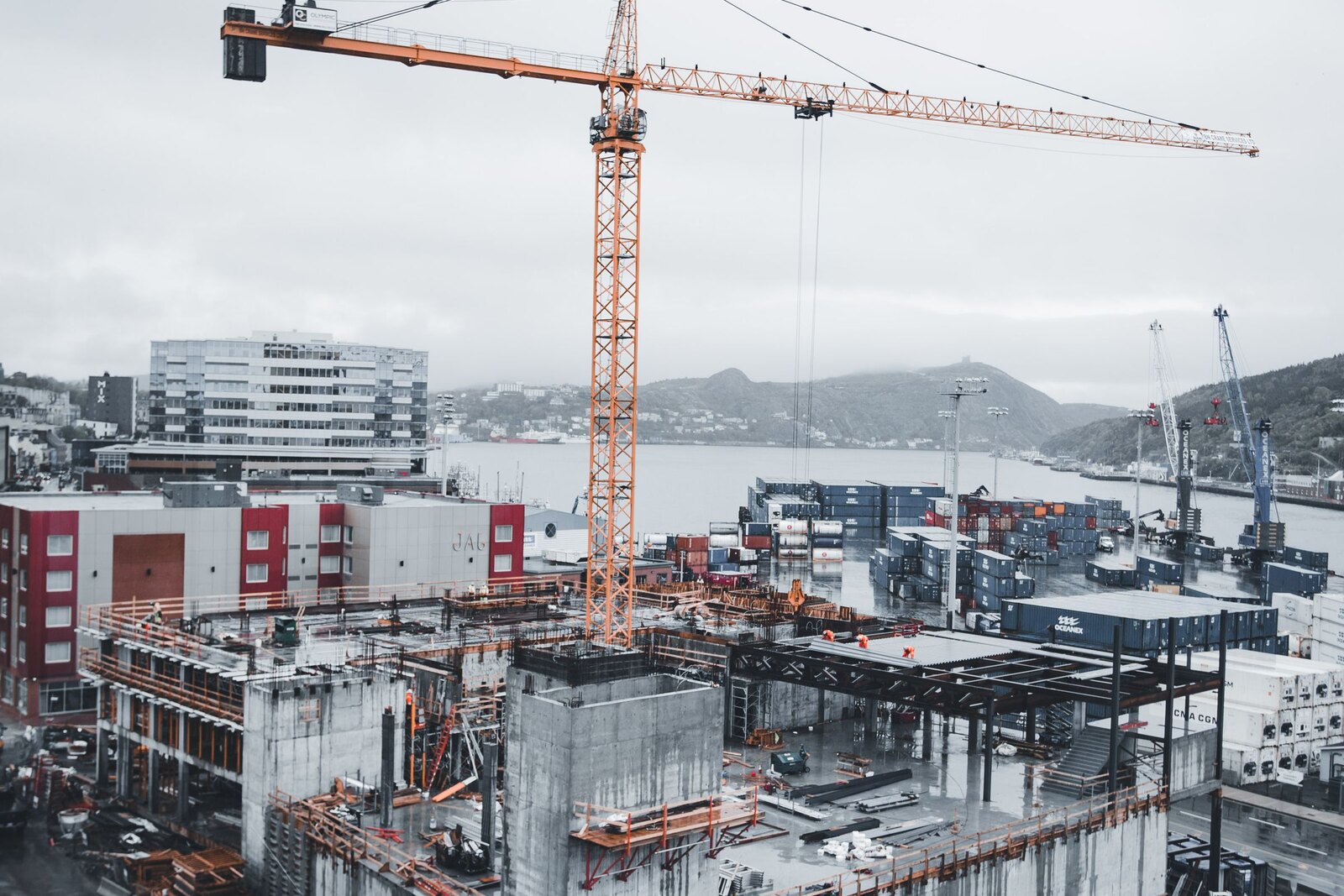 Aerial view of a construction site beside waterfront buildings.