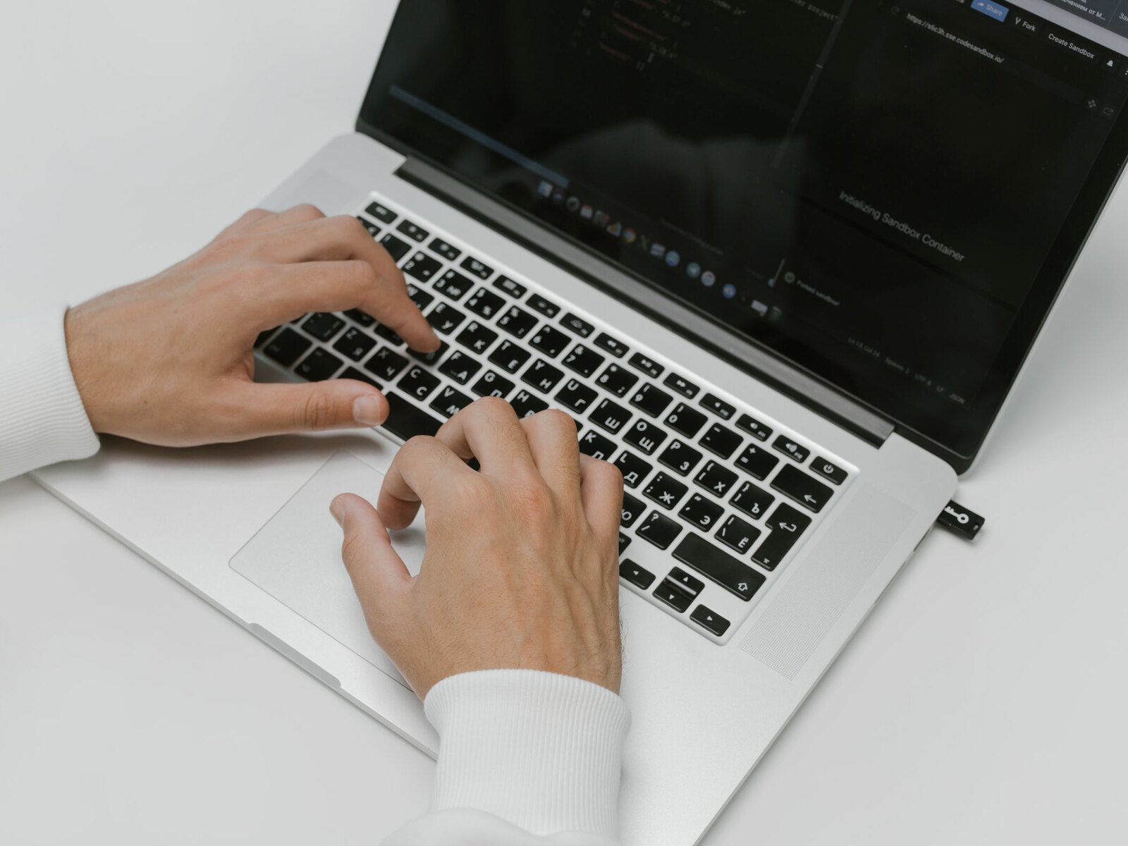 Hands typing on a laptop keyboard.